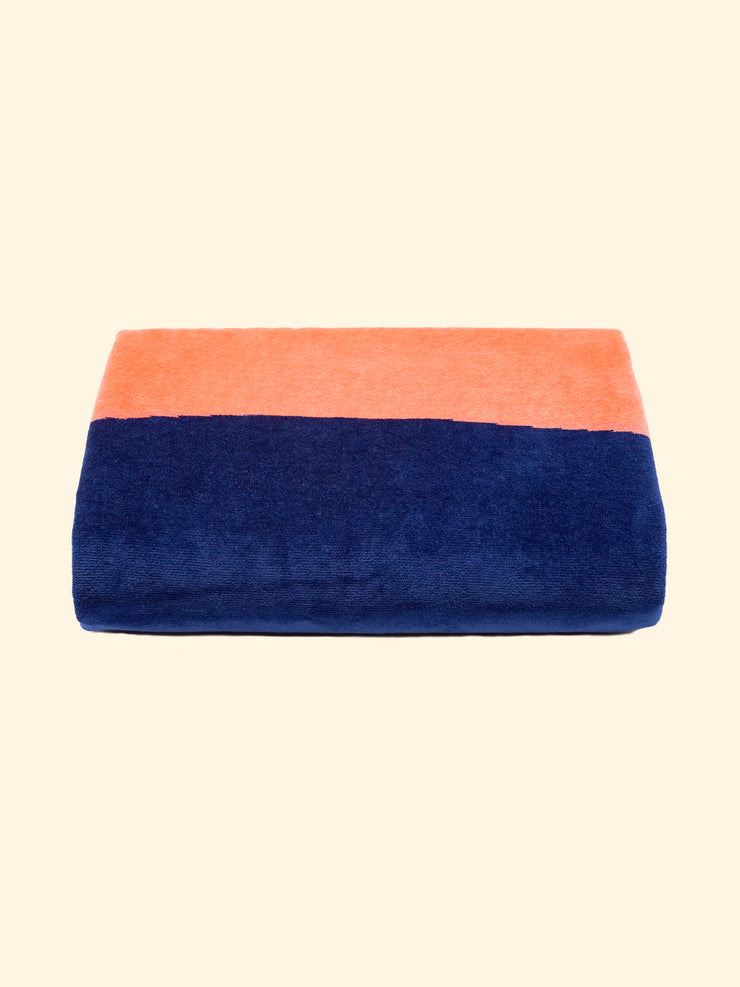 Modelo "Konoh" de Tucca toalla de playa 100% algodón orgánico, perfectamente doblada tal y como se presenta en el embalaje, con dos alfileres en cada lado, los que se pueden utilizar para fijar su toalla de playa a la arena.